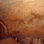 Djanet, Algeria. Large Round Head Period paintings in a sandstone shelter of people standing, walking and appearing to float in space. Image ID: algdja0010032