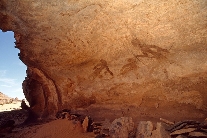 Djanet, Algeria. Large Round Head Period paintings in a sandstone shelter of people standing, walking and appearing to float in space. Image ID: algdja0010032