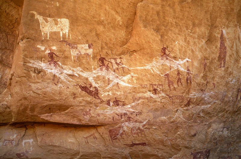 Ennedi plateau. Large panel of Horse/Camel Period bichrome and red paintings of mounted horses and camels, cattle, goats and men. Image ID: chaenp0050028