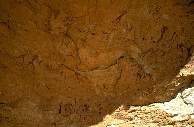 Wadi Sura. Large panel of bichrome maroon and white(?), and faded paintings in main cave. Numerous male figures painted in maroon and probably white (now faded), negative handprints. Round Head Period. Image ID: egywsu0010006