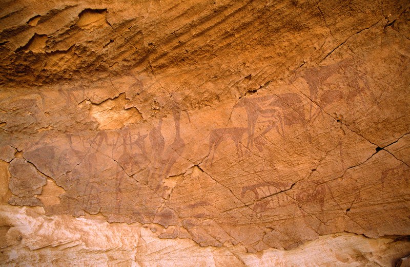 Wadi Sura. Panel of bichrome and maroon early Pastoral or very late Round Head Period paintings of people and cattle in right shelter. Image ID: egywsu0020003