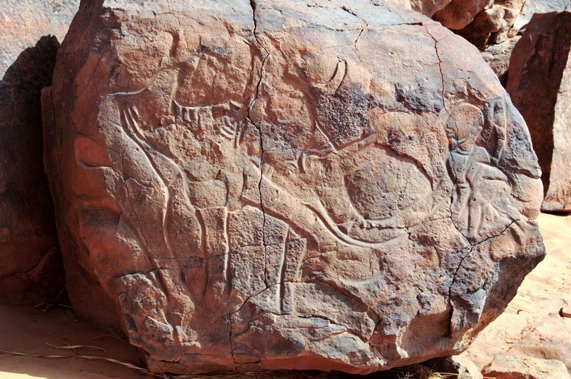 Messak. Polished engraving of human figure facing left. To the left is an elephant. Image ID: libmes0170051