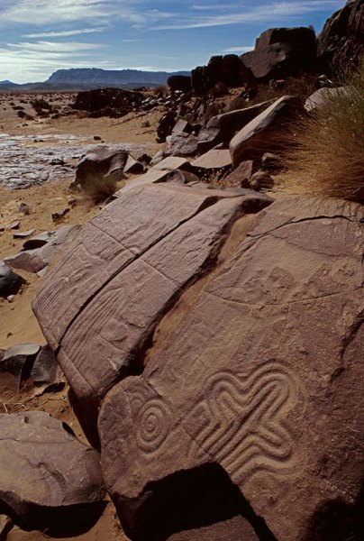 Atlas Mountains, Morocco. Engraved and ground into a sloping sandstone pavement, a number of curvilinear geometric designs including concentric circles, a cross, and a large oval containing vertical parallel lines. Image ID: moratm0080033