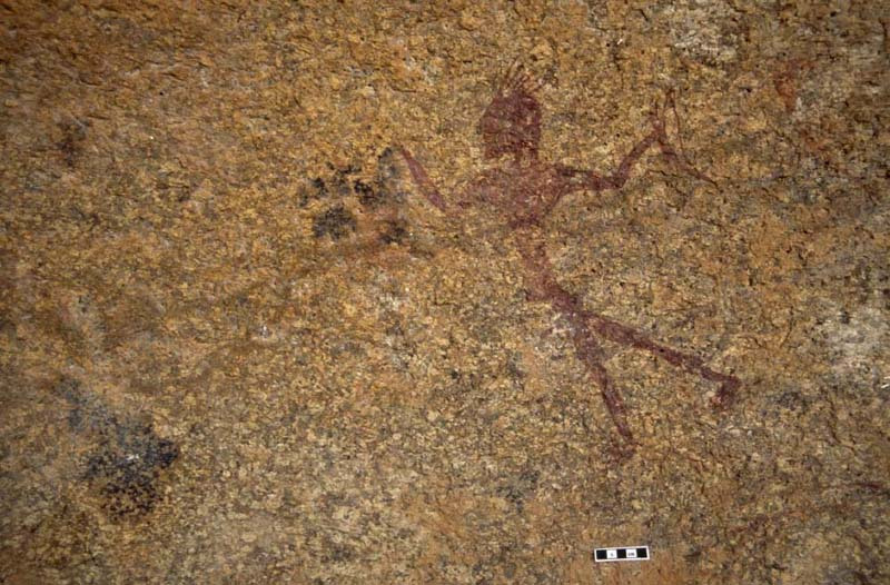 A man holding a bow walks left