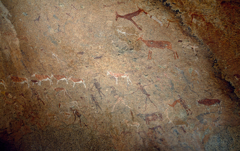 Panel of polychrome paintings featuring the so called White Lady of the Brandberg (central figure striding to left).The painting was so named by a visiting French rock art expert, Henri Abbe Breuil in the 1950s who pronounced the figure to be of Phoenician origin. Experts today point out that the striding figure is in fact a man and that it was undoubtedly painted bt Bushman/San hunter gatherers, probably around 2,000/3,000 years ago. Image ID: namdmb0010010