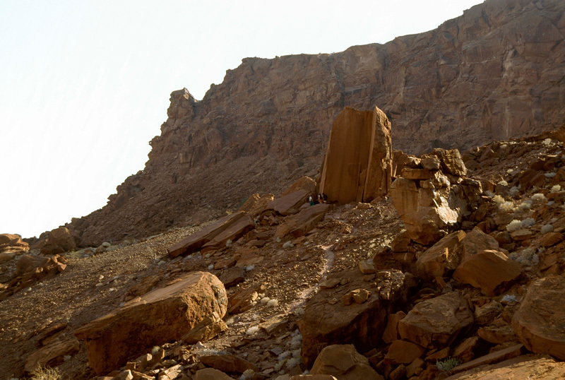 View of the barren hillside at Twyfelfontein (literally, "doubtful spring") where many of the main rock engravings are located.See distant human figures for scale. Image ID: namdmt0010041