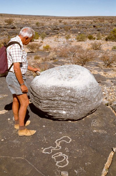 Aar Farm, Namibia. Free-standing boulder, well rubbed on upper surface that also has cupules. When struck, rock chimes. Right next to boulder, geometric design and concentric circles, and foreground, recent curvilinear engravings. Note apparently natural grooves around two sides of boulder. Image ID: namsna0040005