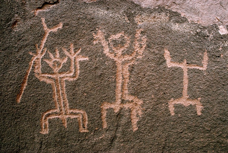 Recent pecked engravings with lines lightly polished of three men with raised hands. Right man has penis and holds stick with fork. Image ID: nignam0030057