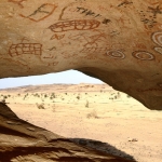 Northern Air Mountain. On roof of low but fairly deep sandstone shelter some four metres above oued, paintings in maroon, red and bichrome of geometric designs and Tifinagh script: bichrome concentric circles, circles, squares, grids and Tifinagh script. Image ID: nignam0020002