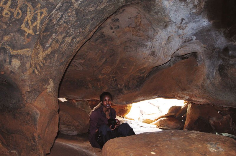 Dhayamole. Numerous painted symbols on cave wall above guides head in S.E Berbera. Image ID: somdha0020007