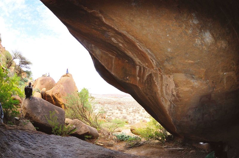 Dhaga Koure. Looking along the ridge from the site. Paintings on lower face of boulder. Image ID: somgab0010005