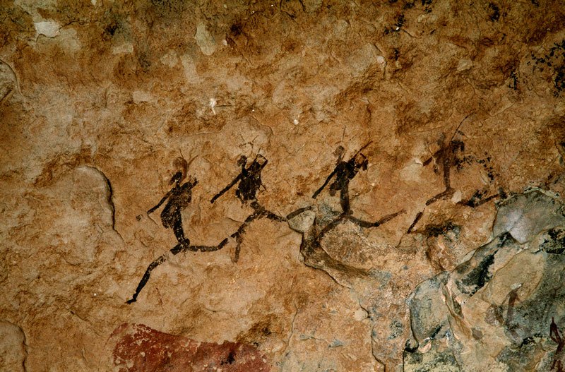 Drakensberg, South Africa. Four running men with gear over shoulders. Image ID: soadrb0060022