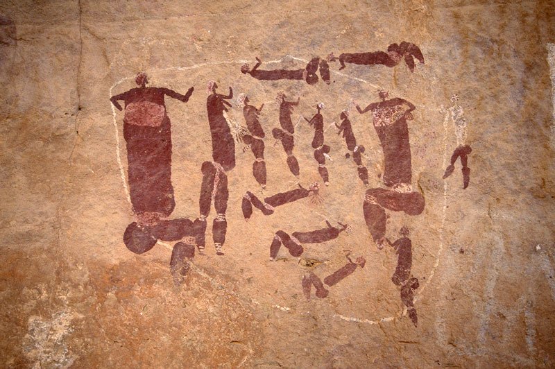 Bichrome deep maroon and white group of naked people dancing. Dance scene includes two large seated women(?) wearing karosses and holding white open triangles. Six women stand holding white open triangles and five people lie prone, one apparently bleeding from nose and four holding white triangles. Image ID: soanec0020037