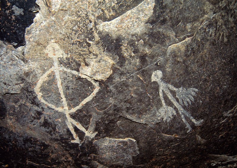 Man with hands on hips and man with large hanging hands with fingers extended. Image ID: tankon0020023