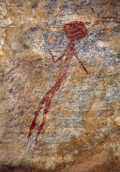 Slender red figure with solid almost-round head, one arm extended and other bent up at elbow, faces forward. Image ID: tankon0030072