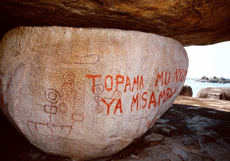Lake Victoria, Uganda. Graffiti written in Kiswahili, in modern oil-based paint, covers some of the original geometric symbols. Translated the graffiti means: 'do not defecate in the Devil's house'. Image ID: ugavic0060003