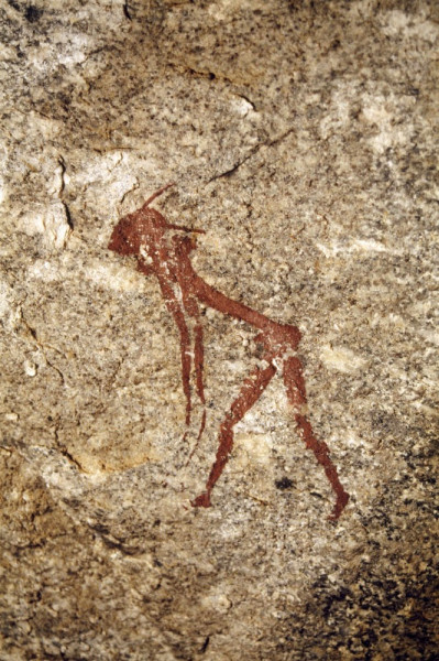 Red graceful man with headdress or mask and white dot body decorations. Facing left, bent at hips and arms hanging. Mashonaland, Zimbabwe. Image ID: zimmsl0040007