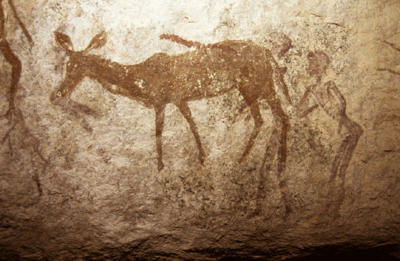 Human figure holds the tail of a female kudu. Possible spiritual connotations. Image ID: zimmsl0220015