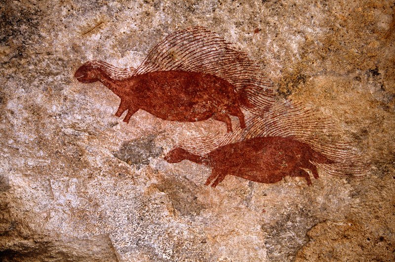 Mashonaland, Zimbabwe. Bichrome maroon and red porcupines facing left. Faded grey antelope with long horns visible before left porcupine and elephant above porcupine’s shoulder. Image ID: zimmsl0020009